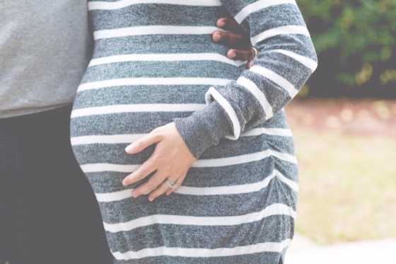 Mulher grávida com as mãos sobre a barriga